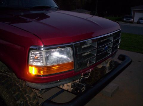 1995 Ford Bronco - Front view of a red Ford truck, likely from the early 1990s, with a prominent chrome grille.