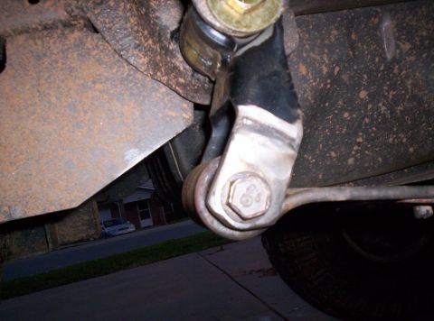 1995 Ford Bronco - Underside view of a vehicle's suspension linkage, showing rust and wear.