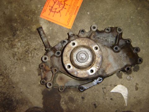 1992 Ford Bronco - A cast iron transfer case with a bolted flange and an output shaft is shown on a concrete floor.
