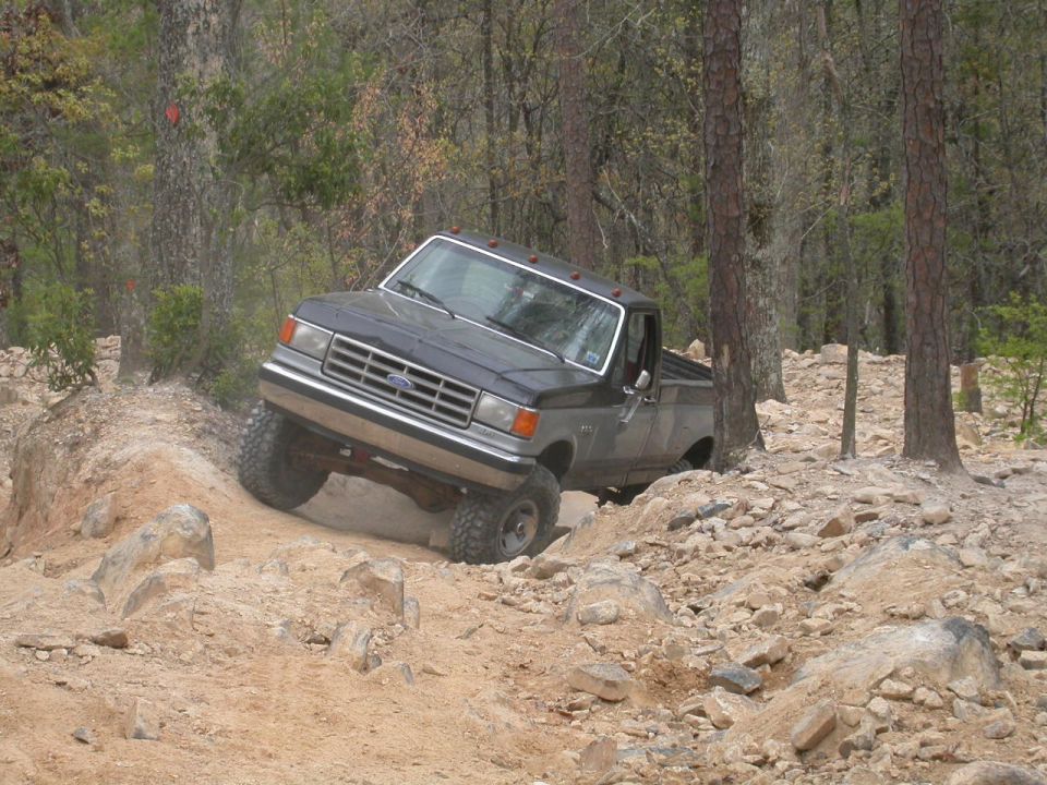 1990 Ford Bronco navigating rocky terrain off-road