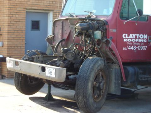 1992 Ford Bronco - A red truck is shown with its front end disassembled, revealing the engine and chassis components.