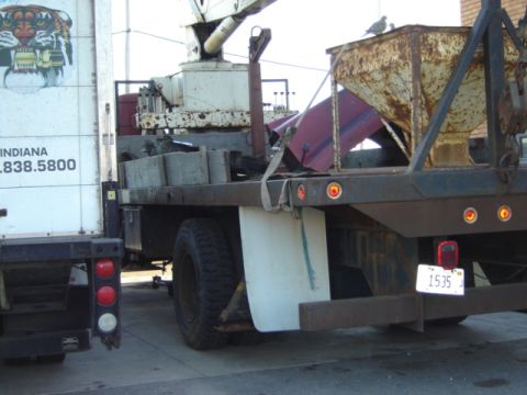 1992 Ford Bronco - Two trucks are parked side-by-side, one with equipment in its bed and the other with contact information on its side.