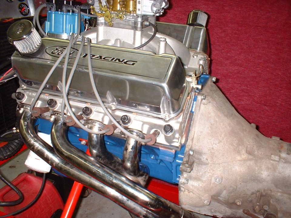 Ford V8 engine block painted blue, with chrome valve covers reading "Ford Racing"