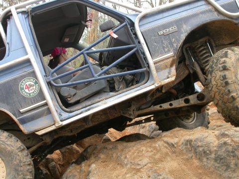 1990 Ford Bronco - This heavily modified 1990 Ford Bronco is navigating a rocky trail with its driver inside.