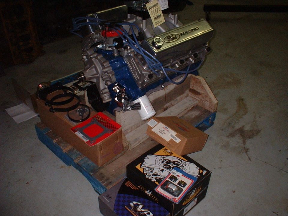 Ford Racing engine on a pallet with engine parts and boxes