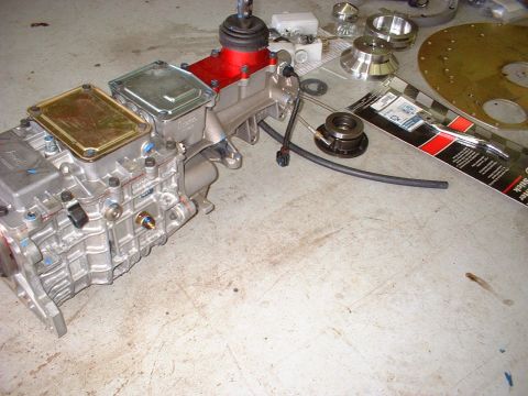 1971 Ford Mustang - Various transmission and clutch components are displayed on a workshop floor, suggesting a rebuild or upgrade project.