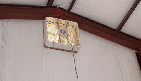 1986 Ford Ranger - A box fan is mounted on a white wall within a structure that has exposed metal beams overhead.
