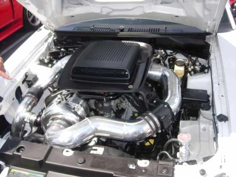 1998 Ford Crown Victoria - engine bay showing a black intake airbox, polished supercharger inlet piping, and a white reservoir cap.
