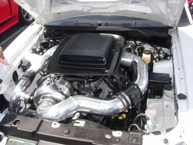 Engine bay with black intake box and polished supercharger piping