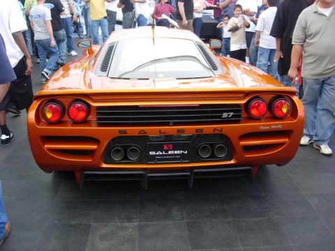 1998 Ford Crown Victoria - Rear view of an orange Saleen S7 supercar with quad exhaust and SALEEN badging, surrounded by spectators.