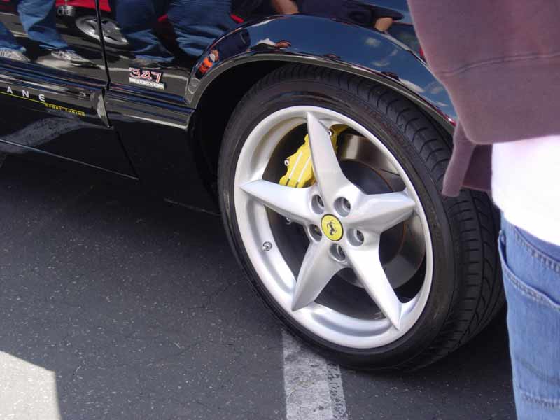 Black car with 347 badge and Ferrari-style wheel with yellow caliper