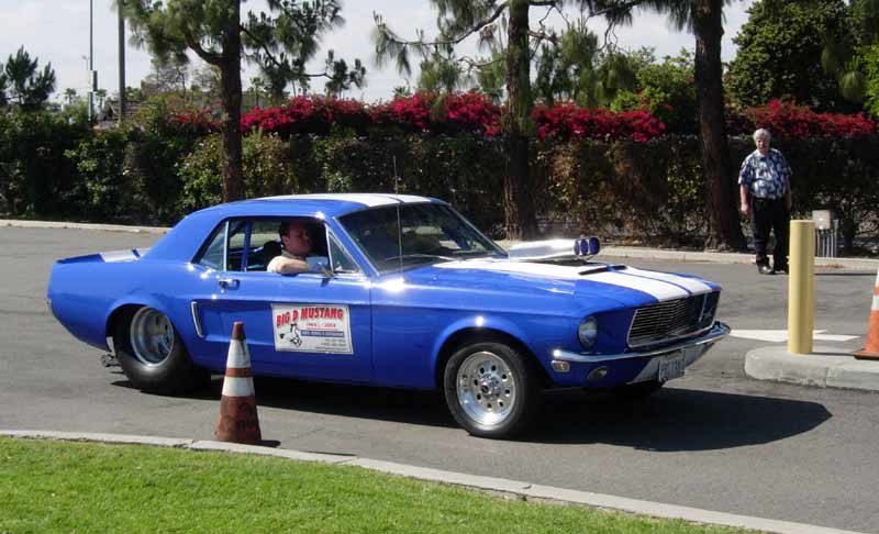 Blue 1968 Mustang coupe drag car with hood scoop turning a corner