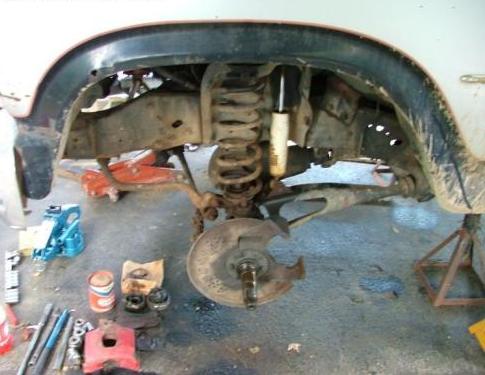 Front suspension of a vehicle on jack stands with tools scattered around