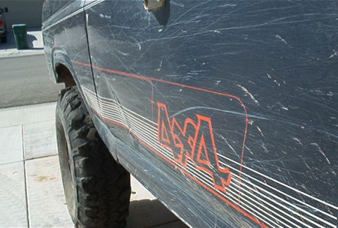 1986 Ford Bronco - This 1980s Ford Bronco shows significant body damage and a 4x4 decal on its side.