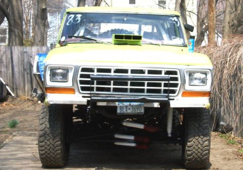1978 Ford Bronco - This modified truck features a prominent hood scoop and lifted suspension, with a New York license plate visible.