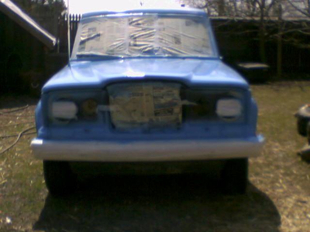 Blue SUV front view, windows taped for painting