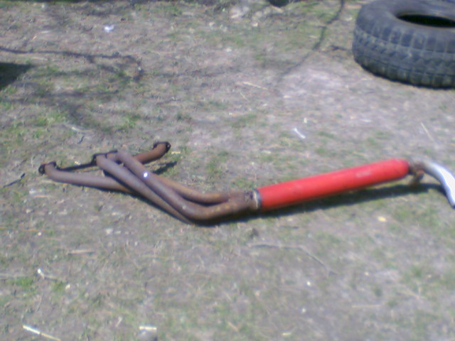 Exhaust manifold with four pipes connected to a red muffler pipe
