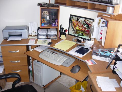 1998 Ford Crown Victoria - wooden home office desk with a flat monitor displaying a flamed hot rod, keyboard, printer and a blue model car.