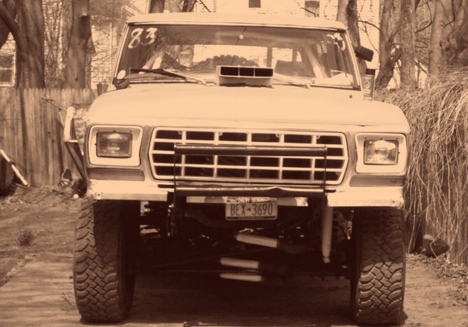 Front view of a lifted 1978 Ford Bronco with a hood scoop and off-road tires