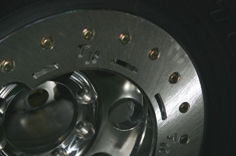 1995 Ford Bronco - A close-up view of a vehicle's wheel and tire assembly, showing metallic details and some inscribed markings.