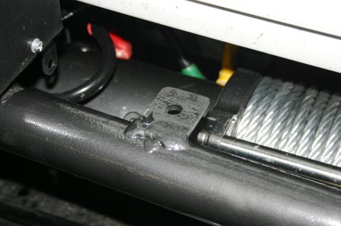 1995 Ford Bronco - Close-up of a winch and its mounting hardware, showing a steel cable and welded bracket.