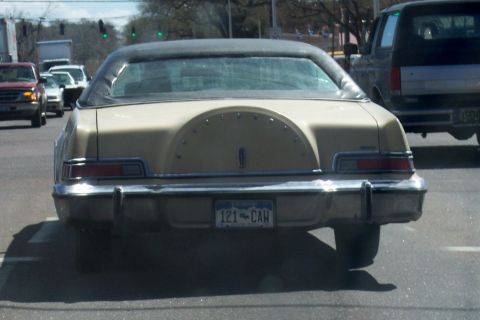 1972 Ford Ranchero - Rear view of a 1976 Lincoln Continental Mark IV driving on the road.
