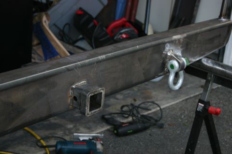 1995 Ford Bronco - Close-up of a custom steel bumper assembly, showing a hitch receiver and a D-ring tow hook.