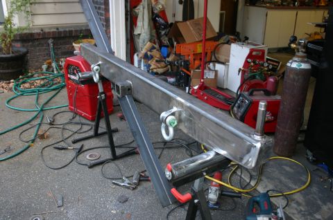 1995 Ford Bronco - Fabrication of a custom steel bumper is underway, surrounded by tools and equipment in a workshop setting.