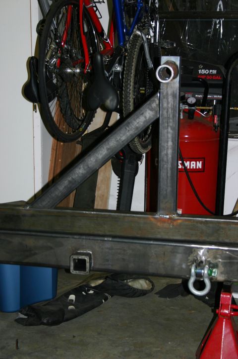 1995 Ford Bronco - A custom-fabricated rear bumper assembly is shown with a hitch receiver and tow shackle, alongside an air compressor and bicycles.