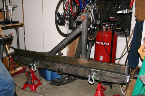1995 Ford Bronco - A custom-fabricated rear bumper assembly, likely for an SUV or truck, is shown in a workshop setting with a tire carrier mount.