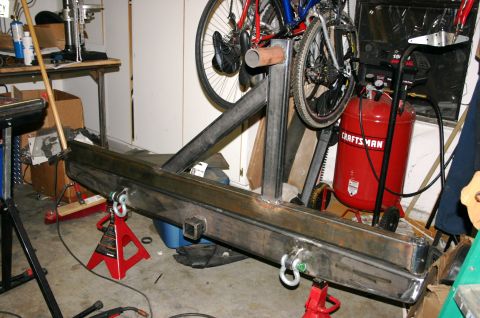 1995 Ford Bronco - Custom rear bumper assembly in a workshop setting, supported by jack stands.