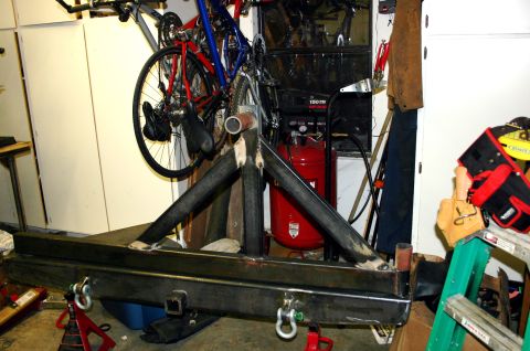 1995 Ford Bronco - A custom-fabricated rear bumper assembly with a tire carrier mount and tow hitch receiver is shown.