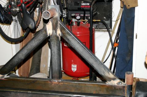 1995 Ford Bronco - A close-up view of a custom-welded metal frame, with an air compressor and bicycles visible in the background.
