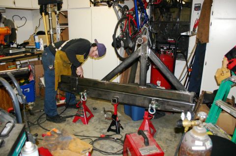 1995 Ford Bronco - Custom metal fabrication in progress, with a person welding a large frame assembly.