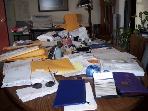 1972 Ford Ranchero - A cluttered desk surface with numerous documents, envelopes, and office supplies is visible.
