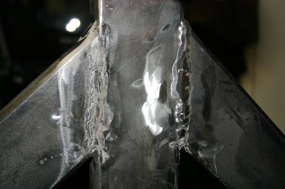 Close-up of rough welds on a metal bracket, possibly part of a tire carrier