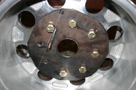 1995 Ford Bronco - A close-up view of a wheel hub assembly, showing the mounting bolts and a central opening.