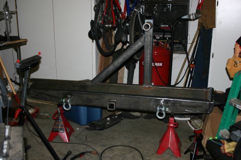 1995 Ford Bronco - Custom rear bumper assembly with integrated tire carrier mount and tow hitch receiver, supported by jack stands.