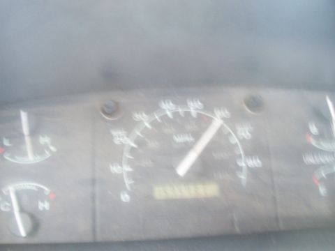 1994 Ford F-150 - Out-of-focus photo of a dusty truck instrument cluster with the speedometer needle around 60 MPH and the odometer numerals too blurred to r…