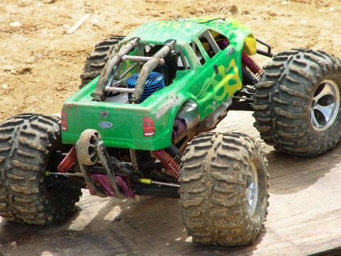 1994 Ford Bronco - This remote control monster truck features a bright green body with flame graphics and oversized off-road tires.