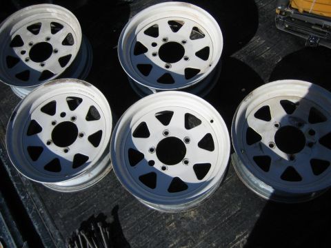 1987 Suzuki Samurai - Set of five white off-road wheels, likely for an SUV or truck, are stacked and ready for installation.