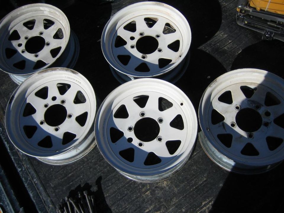 five white off-road wheels with triangular cutouts