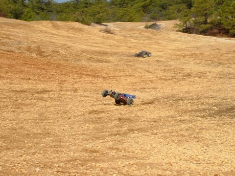 1994 Ford Bronco - Two remote control buggies race across a dusty, off-road track.