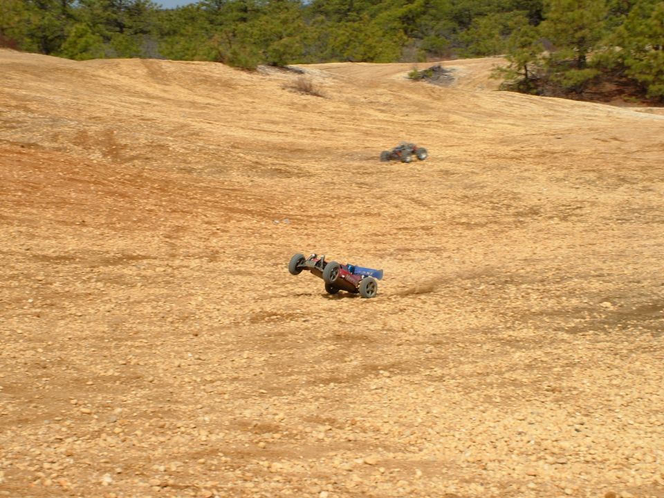 Remote control buggy on dirt track with another in background