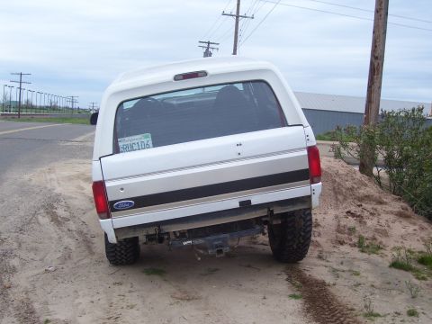 1994 Ford Bronco - Rear view of a 1994 Ford Bronco parked on a dirt road.