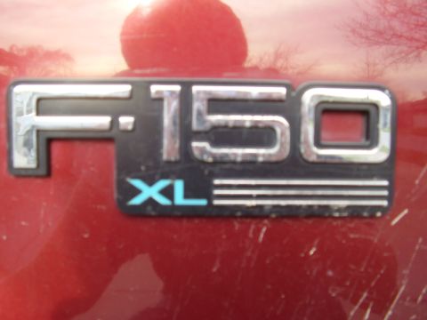 1996 Ford F-150 - The F-150 XL emblem is shown on the side of a red vehicle.