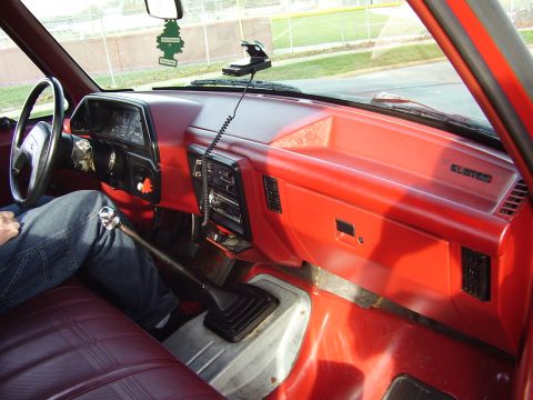 1996 Ford F-150 - Interior view of a red truck, a manual transmission and "CUSTOM" badging on the dashboard.