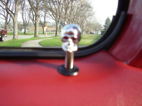 1996 Ford F-150 - Interior view of a red vehicle with a skull lock pin, showing a red pickup truck outside.
