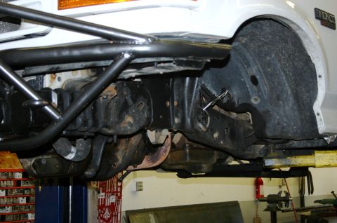 1995 Ford Bronco - Close-up of the front suspension and frame of a 1995 Ford Bronco, a roll cage and Fox coilovers.