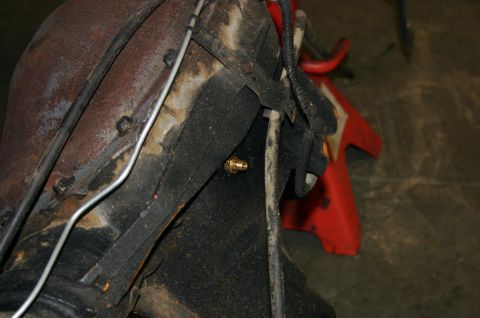 1995 Ford Bronco - Detail of a brass fitting attached to a vehicle's suspension component.